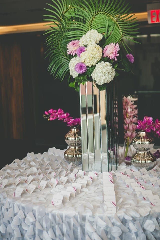 Stunning pink and purple floral arrangement and receiving table with place cards. To see more of this modern wedding, visit Rebecca Chan Weddings and Events http://www.rebeccachan.ca