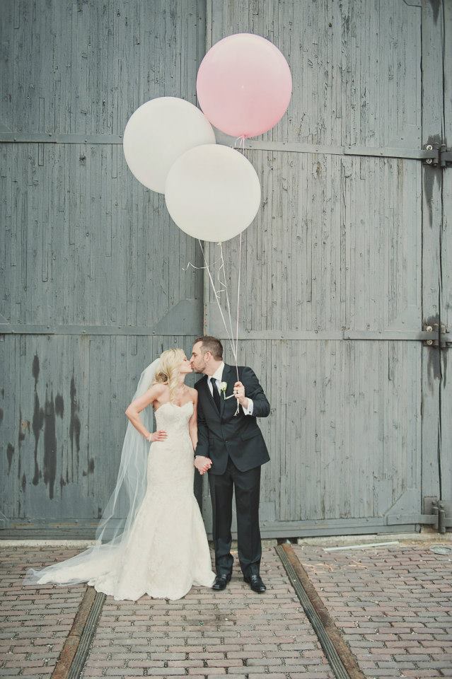 The bride and groom take fun photos with giant balloons.  www.rebeccachan.ca