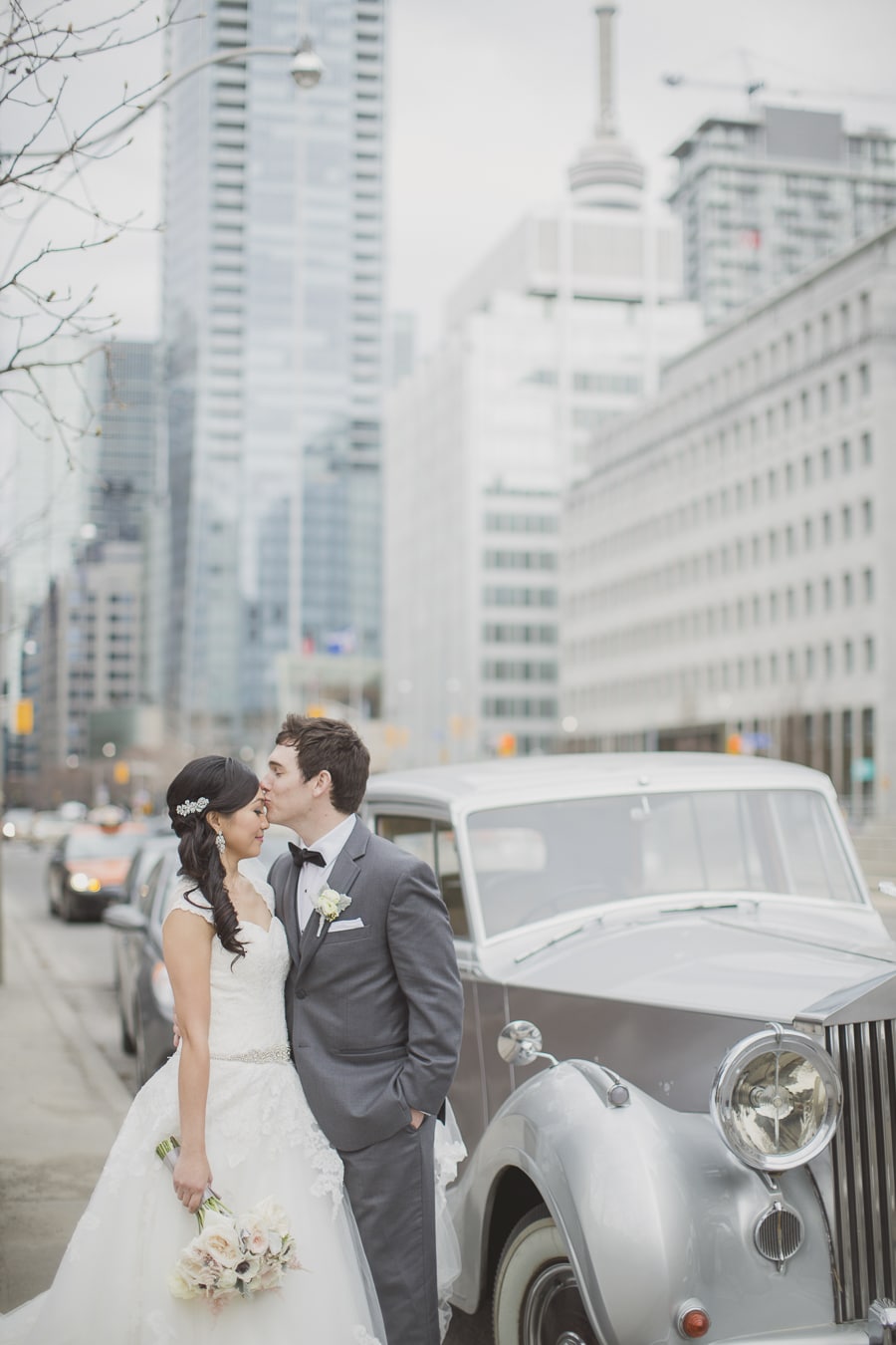 Bride and groom pose outside their Rolls Royce. See more at Rebecca Chan Weddings and Events https://www.rebeccachan.ca