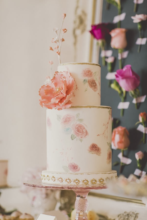 Wedding cake with hand painted floral with flower backdrop. Coral and Gold Wedding Inspiration - See more at Rebecca Chan Weddings and Events www.rebeccachan.ca